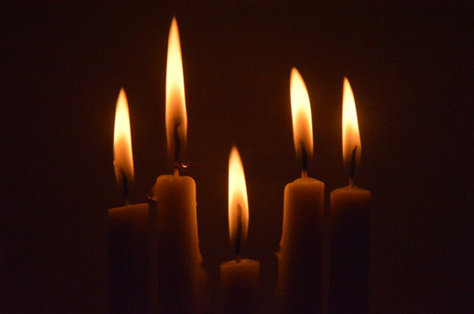 a group of lit candles in a dark room