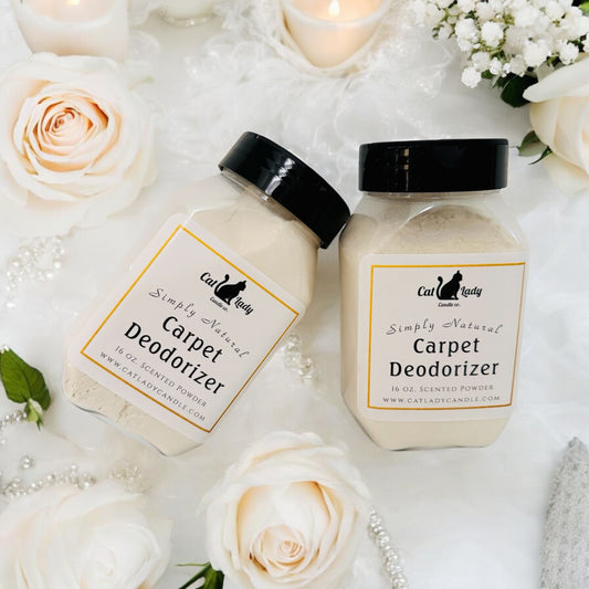 Two containers of carpet deodorizer with simple labels, one labeled 'Jasmine Deodorizer' and the other 'Honeysuckle Deodorizer'. The containers are placed on a white surface with rose petals, and there's a candle in the background, suggesting a home decor setting.